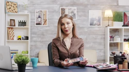 Zoom en la foto de una hermosa vlogger de moda que presenta diferentes cosméticos para la piel