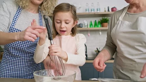 Three Generations of Women Cooking Together Indoors