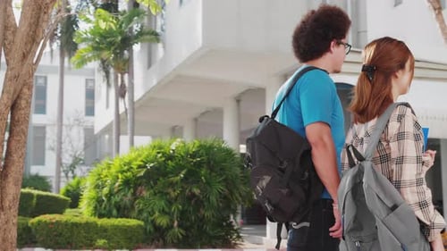 Dolly shot and slow-motion of an attractive multiracial couple of college students walking