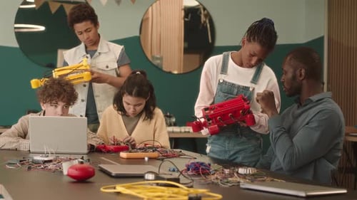 School Kids and Teacher Constructing Robots in Classroom