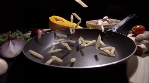 Pasta fliegt in der Luft auf schwarzem Hintergrund in Zeitlupe