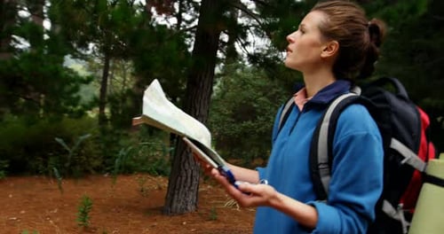 Woman Hiker Navigating with Map and Compass in Forest