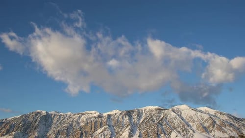 Snowy Mountains and Cloudy Blue Sky