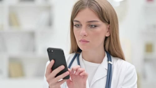 Female Doctor Uses Phone in Hospital Close Up