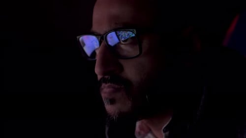 Homme sérieux avec reflet de l'écran d'un ordinateur portable avec des données de site Web dans des lunettes travaillant tard, gros plan.
Dans