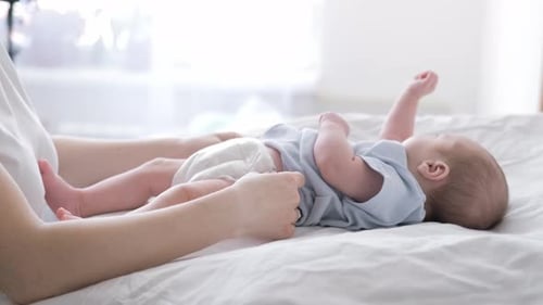 Mother Changes Diapers to Her Newborn Baby Little Boy on Changing Table in Clean Dry Nappy Mom