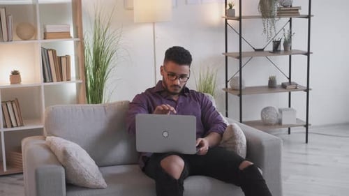 Adult Using Laptop on Sofa Indoors