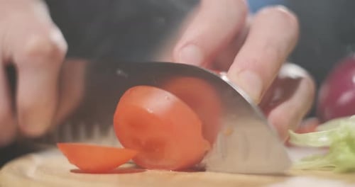 The Cook Slices Tomato By Sharp Knife on the Wooden Board. Making of Vegetable Salad, Vegetarian