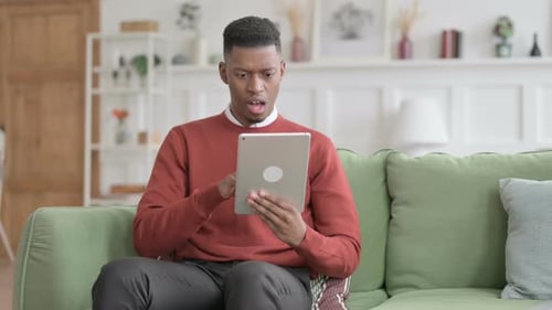 Young Adult Using Tablet Shocked by Content