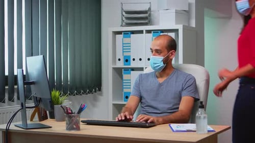 Collègues avec masques faciaux travaillant