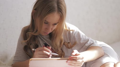 Girl Drawing on Tablet with Stylus at Home