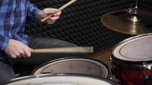 Professional drummer is hitting drum cymbals with drumsticks, close up