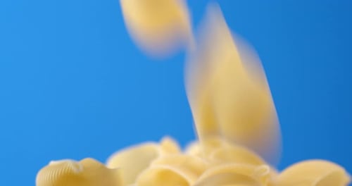 Dry Pasta Conchiglie Falls in a Heap on the Table.