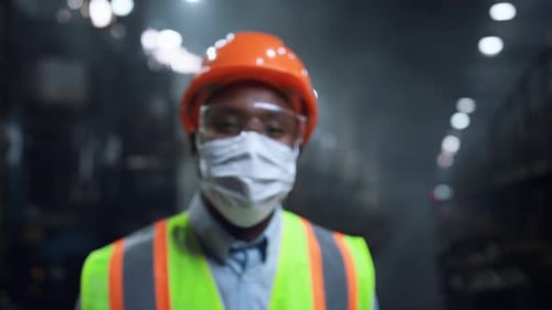 Masked Supervisor Looking Camera at Huge Energy Manufacturing Special Factory