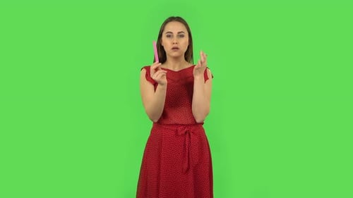 Tender Girl in Red Dress Is Making Herself Manicure with Pink Nail File. Green Screen