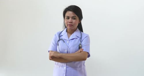 Confident Young Woman in Medical Uniform Folds Arms