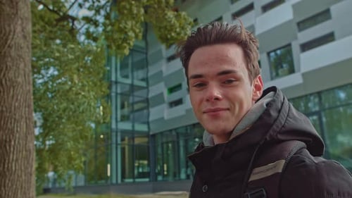 Smiling Young Adult in Front of Modern Building