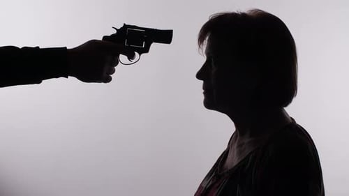 Hombre apuntando con un arma a una mujer