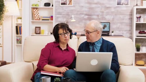 Mature Couple Using Laptop Together in Living Room