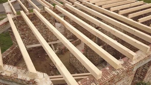 Luftaufnahme eines Backsteinhauses mit Holzdeckenrahmen im Bau
