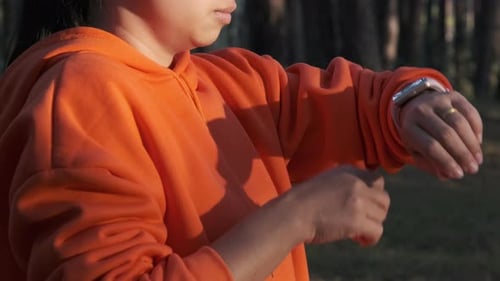 Woman Using Smart Watch in Forest