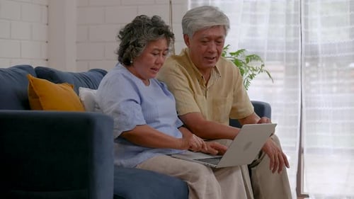 Senior Couple Using Laptop on the Couch