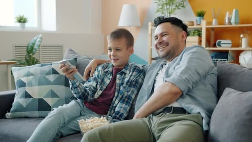 Father and Son Watching Television at Home
