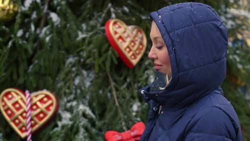 Woman Smiling in Front of Decorated Christmas Tree
