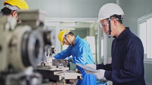Factory Workers Operating Industrial Equipment in Workplace