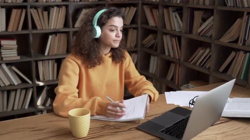 Woman Studying Online in Library with Laptop