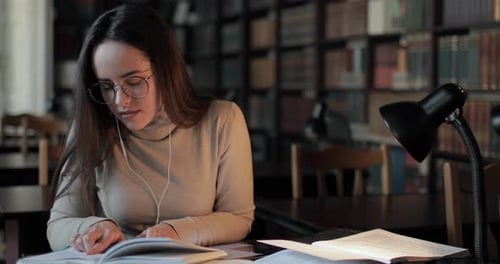 Girl Studying and Typing on Tablet in Library