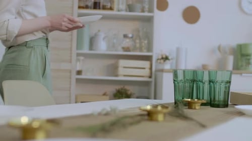 Woman Sets Table with Plates for Dinner