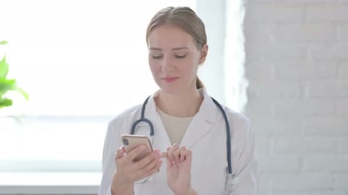 Female Doctor Using Smartphone in Bright Office