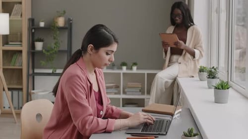 Par de jovens empresárias diversas trabalhando no escritório