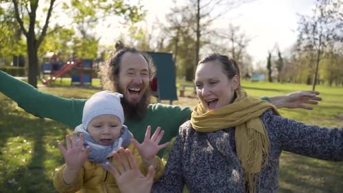 POV image of family playing at merry-go-round in public playground.
