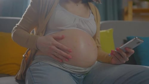 Pregnant Woman Using Smartphone at Home