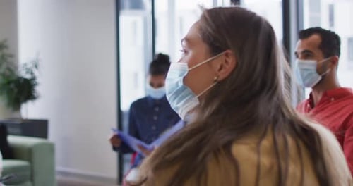 Coworkers Have a Meeting Wearing Face Masks Indoors