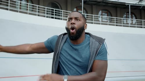 Athlete in Sportswear Dancing on Stadium. Sporty Man Singing Song Outdoors