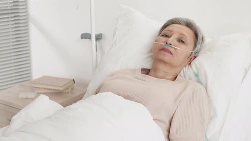 Senior Woman Patient Lying in Hospital Bed
