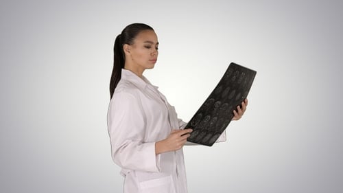 Woman Doctor Looking at X-Ray Image in Hospital