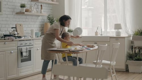 Woman Helps Child With Play Dough in Kitchen