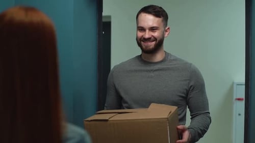 Man Delivering Cardboard Box to a Home