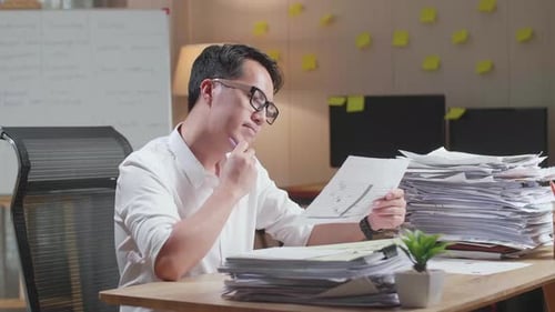 Man Finding Solution with Documents in Office
