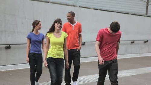 Four Young Adults Walking and Talking Together