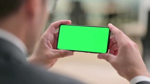 Man Holding Smartphone with Green Screen for Compositing