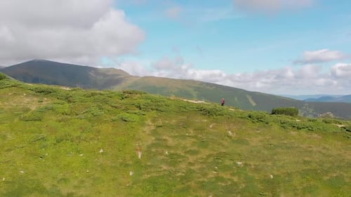 Aerial View of a Traveler with a Backpack Climbing By Mountain Range. Epic Shot