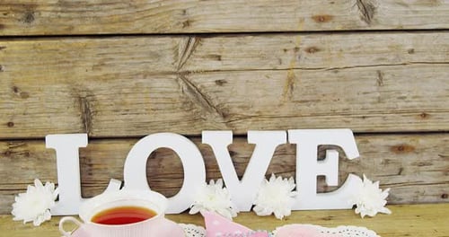 Teacup, Cake, and Love on Wooden Table