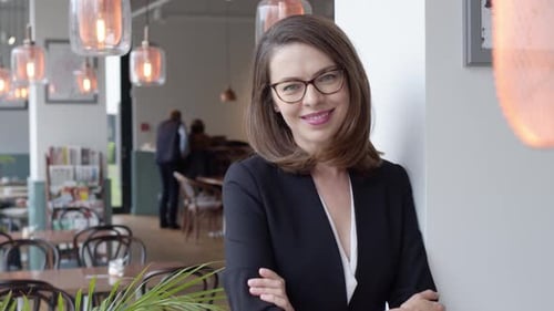 Portrait of Young Smiling Businesswoman Standing in Modern Office Interior