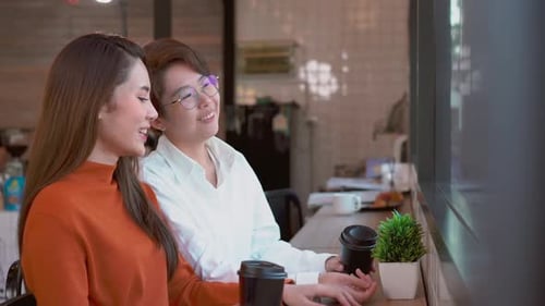 Two Women Chatting Over Coffee in Cafe