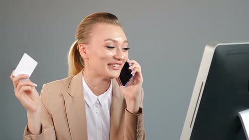 Woman Laughing on Phone Holding Credit Card